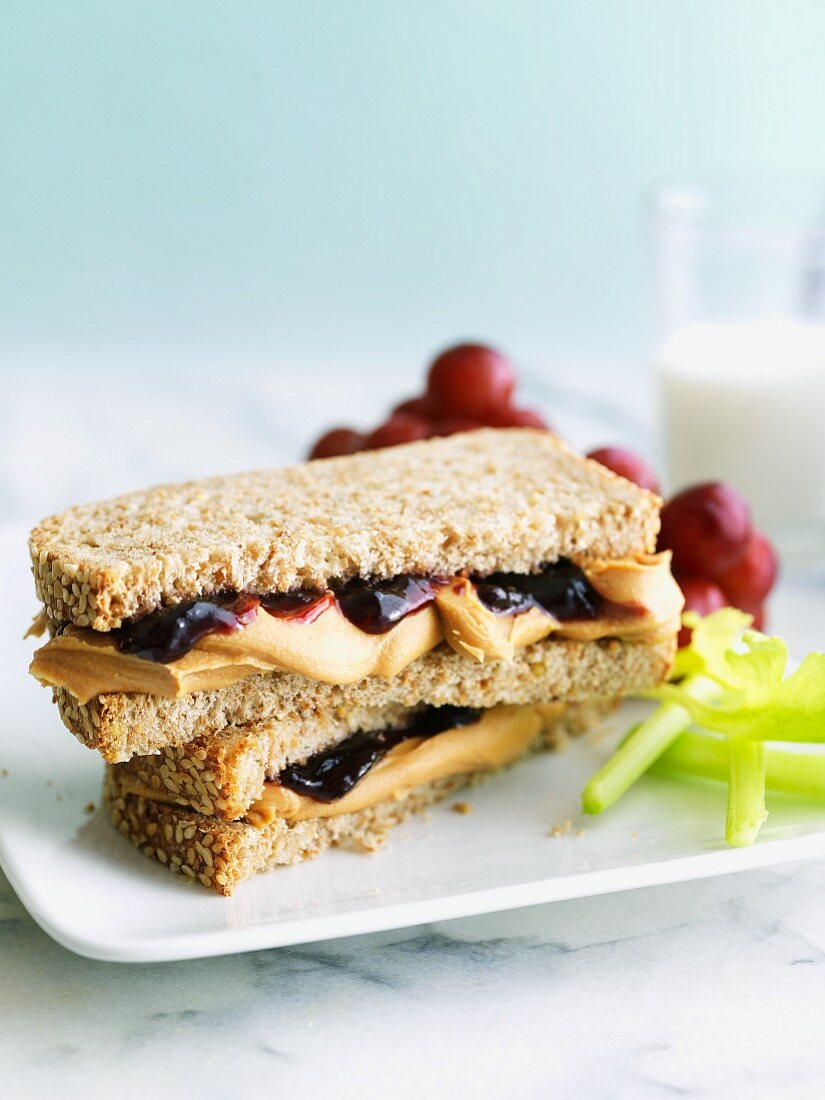 Peanut Butter and Jelly Sandwich on Wheat Bread with Celery and Grapes