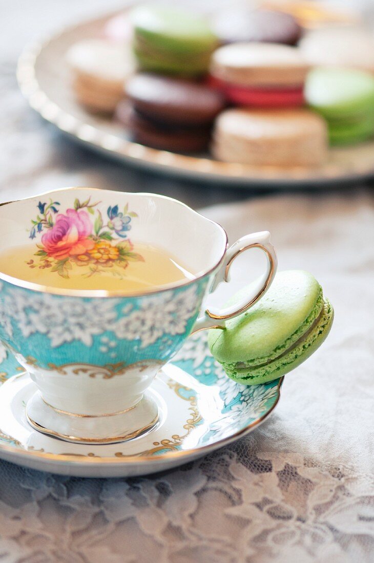 Pretty Tea Cup on a Saucer with a Green Macaroon