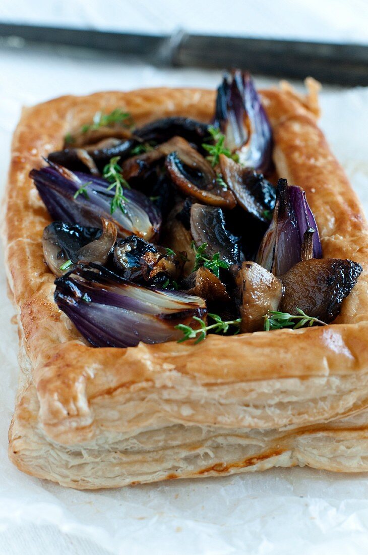 A puff pastry tart with mushrooms and red onions