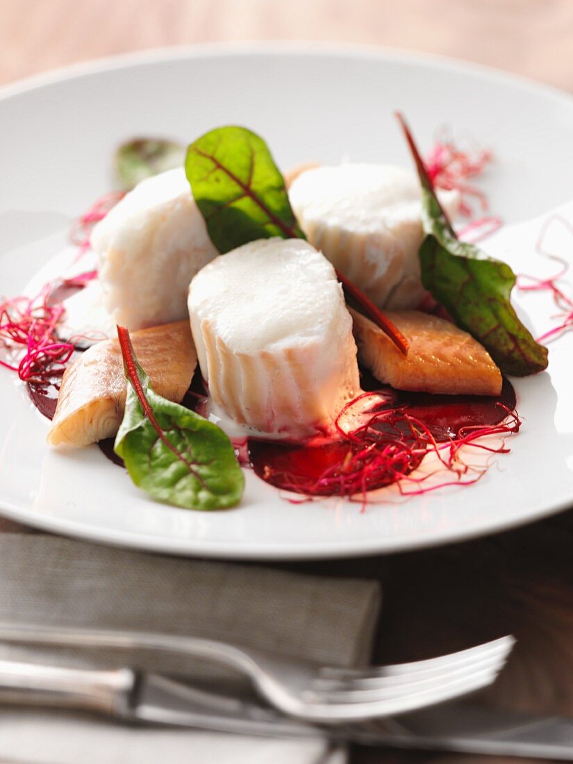 Poached cod with smoked fish on a beetroot salad