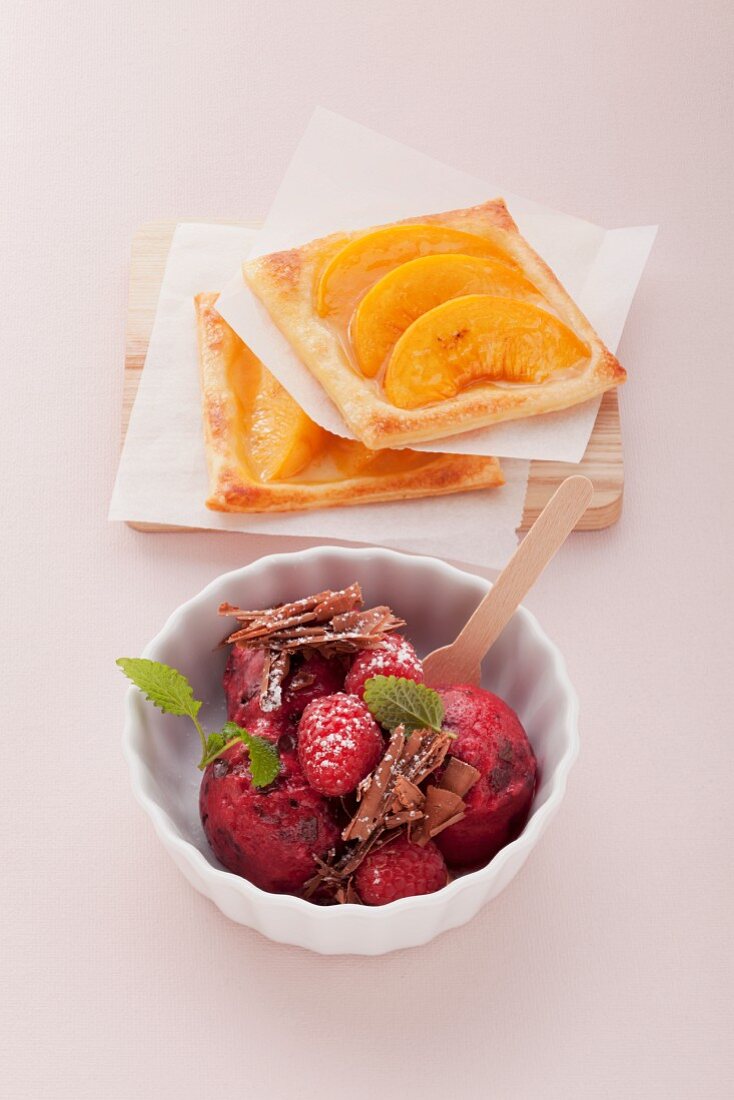 Peach puff pastry tartlets and raspberry ice cream with grated chocolate