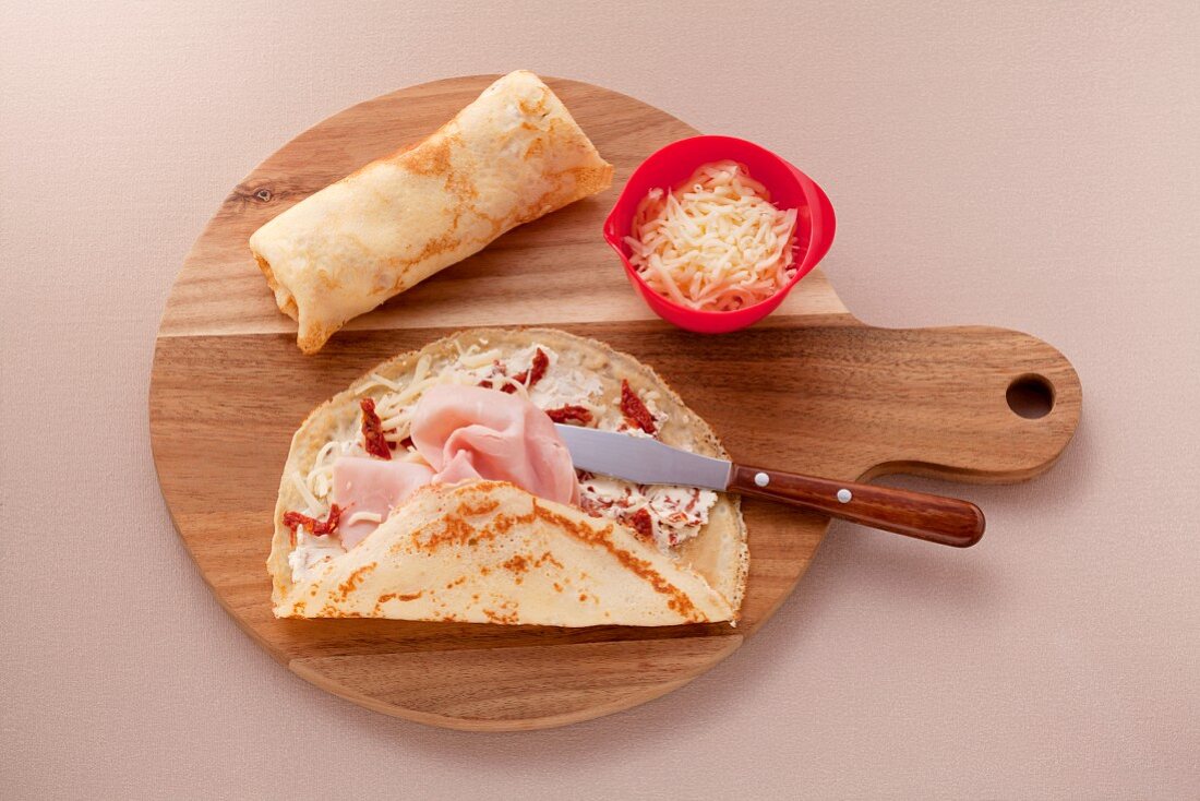 Crepes with dried tomatoes, ham and grated mozzarella