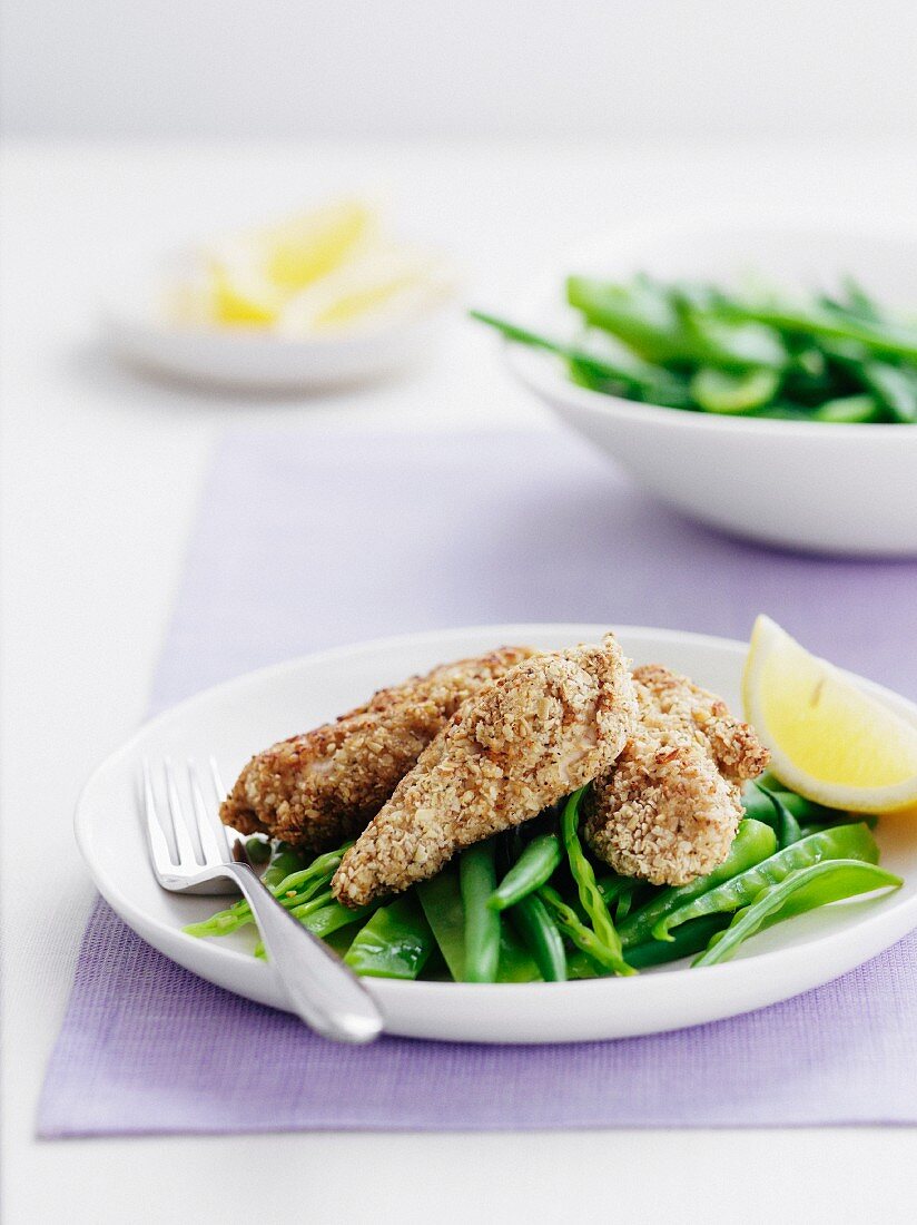 Chicken with an oat crust on a bed of green beans