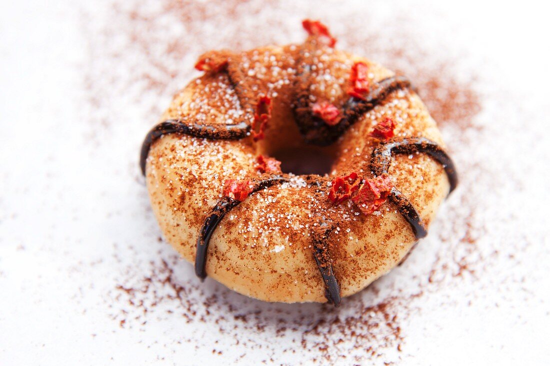 A doughnut with chocolate glaze, cocoa powder and chilli