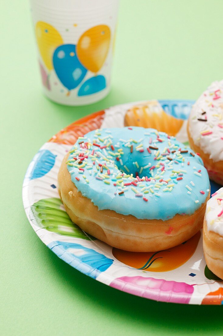 A blue-glazed doughnut decorated with sugar sprinkles