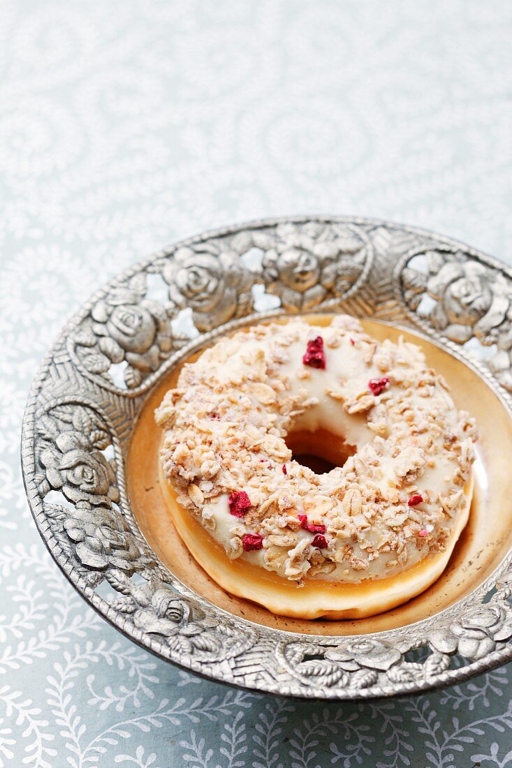 A doughnut topped with oats and cranberries