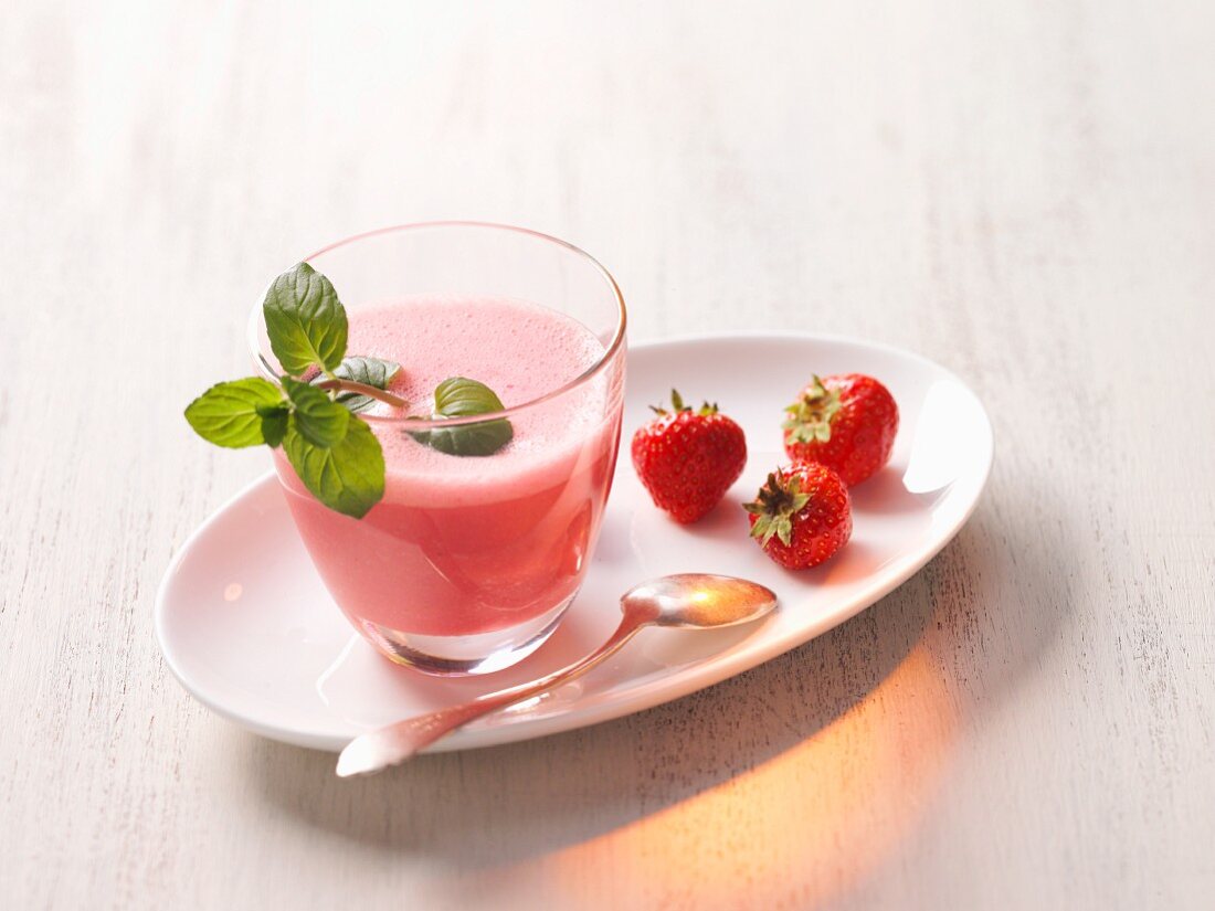 A strawberry shake with a sprig of mint