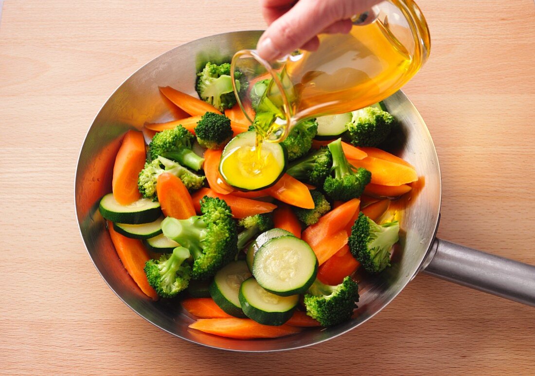 Flaxseed oil being added to stir-fried vegetables