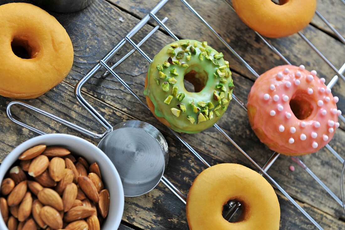 Doughnuts topped with glaze, pistachios, sugar balls and almonds