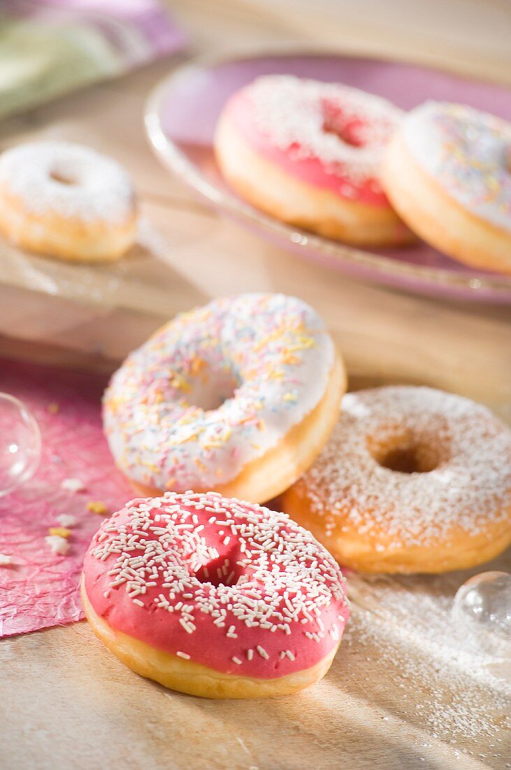 Doughnuts with a raspberry glaze, icing sugar and sugar