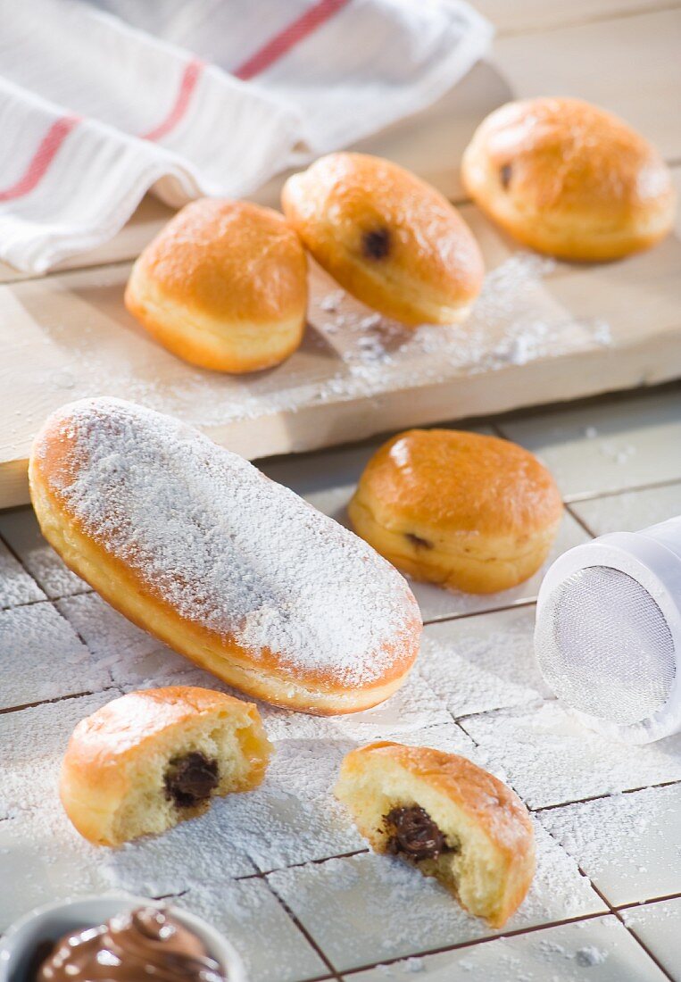 Freshly baked chocolate-filled doughnuts dusted with icing sugar