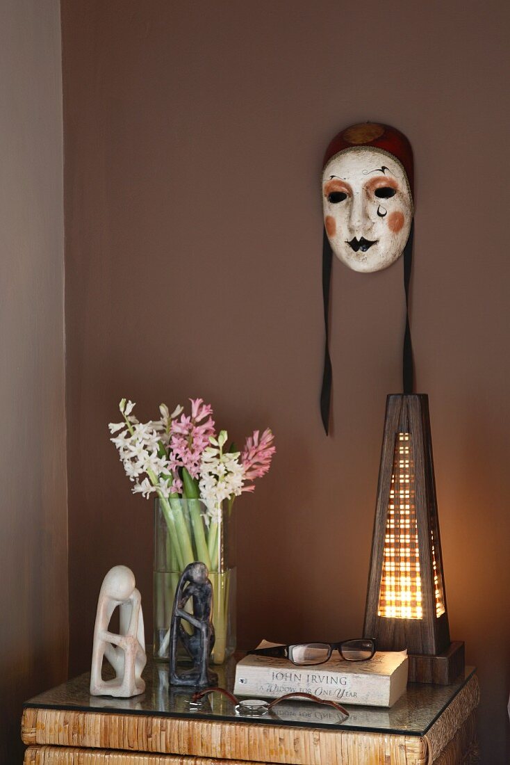 Hand painted Venetian masks on a brown wall above a night stand