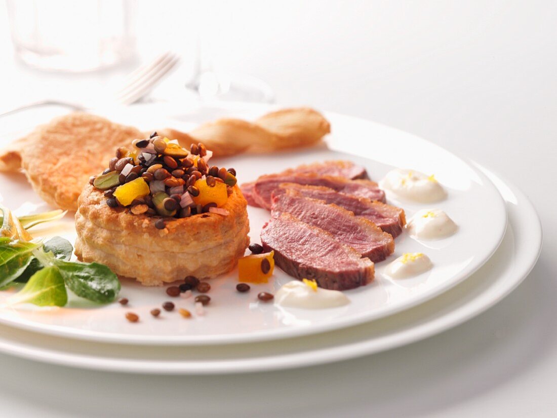A vol-au-vent filled with lentil salad and duck breast