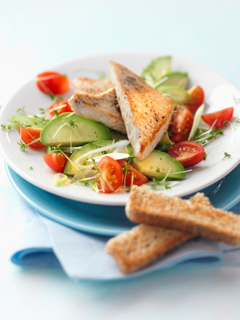 Avocado salad with cherry tomatoes and fish fillet