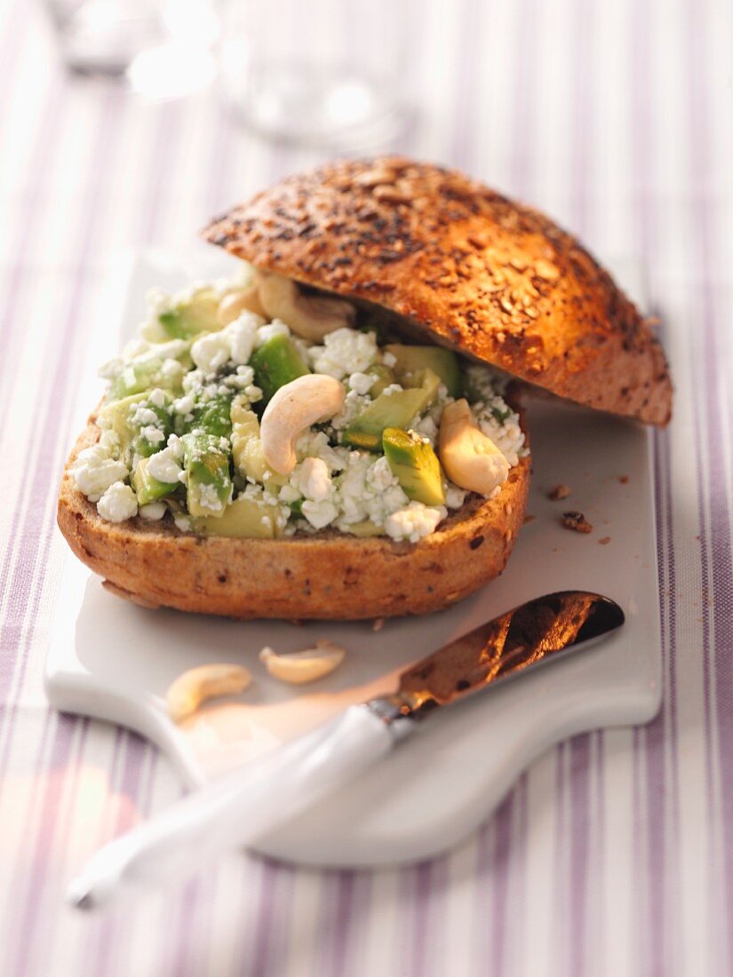 Cottage cheese, avocado and cashew nuts on a seed roll