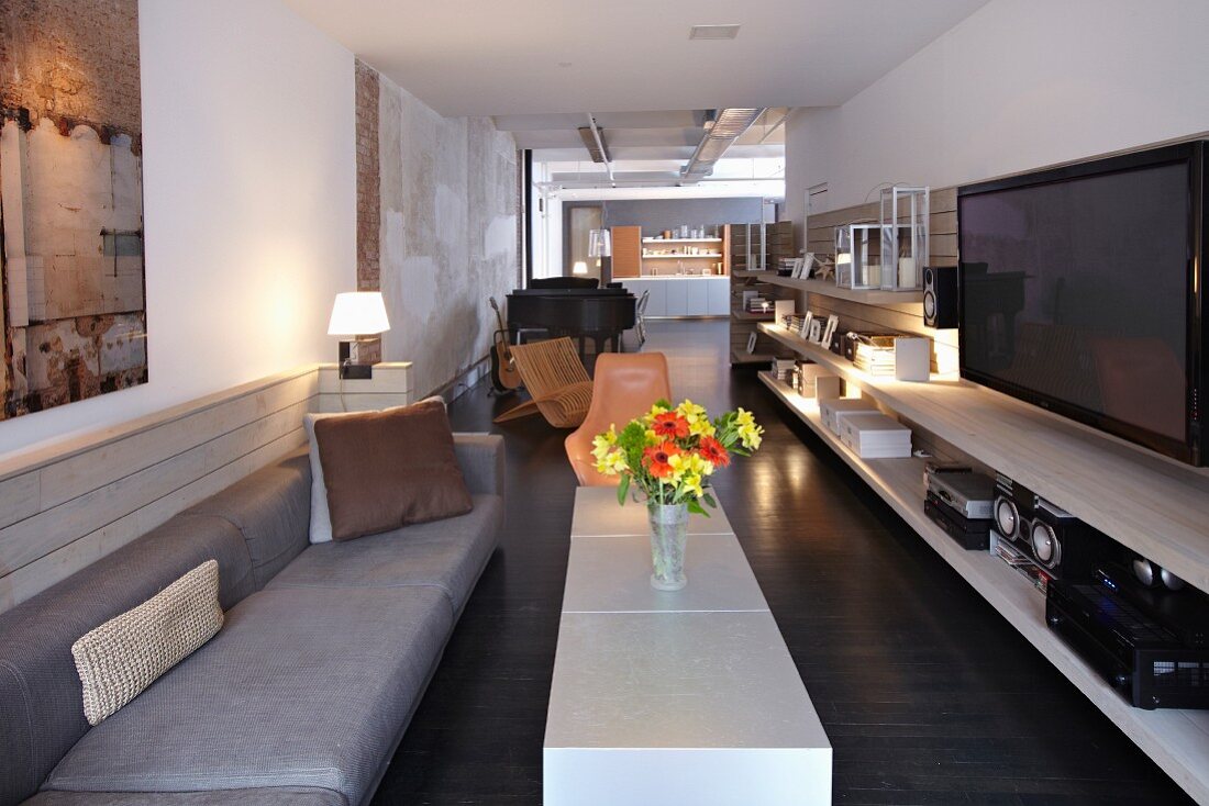 Langgezogenes Wohnzimmer mit Loftcharakter im Designerstil