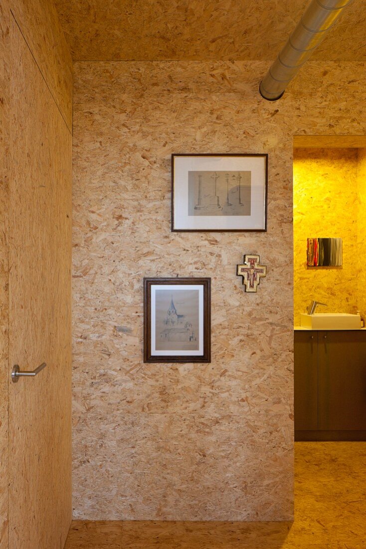 Interior clad in chipboard with view of washstand through open doorway