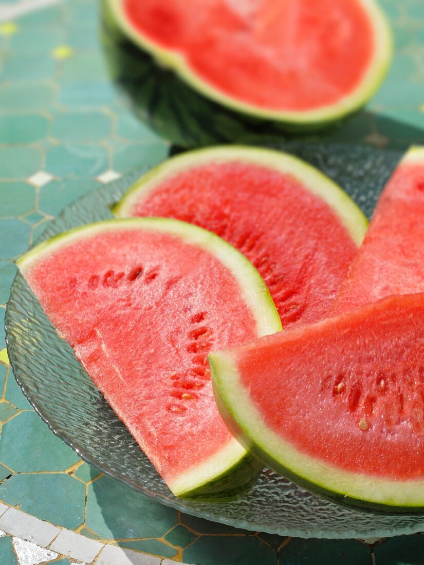 Wassermelonenspalten und halbe Wassermelone
