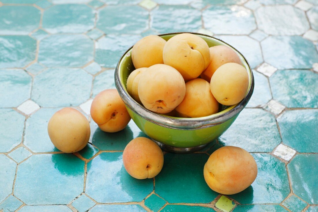 Apricots in a metal bowl and next to it