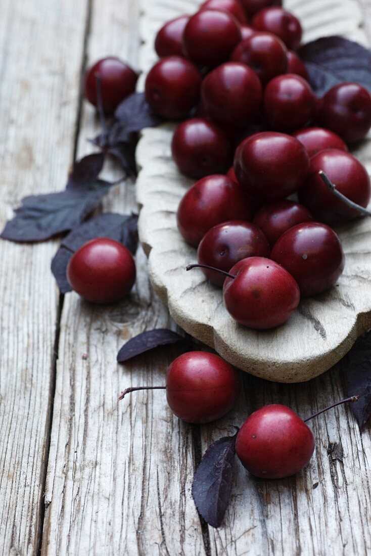 Plums with leaves in a bowl