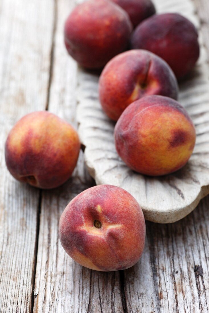 Peaches in a wooden bowl and next to it