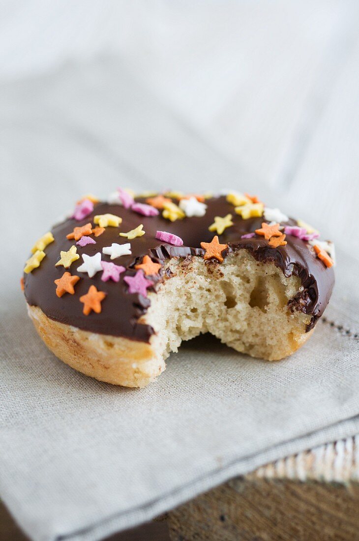 A doughnut with chocolate glaze and sugar stars