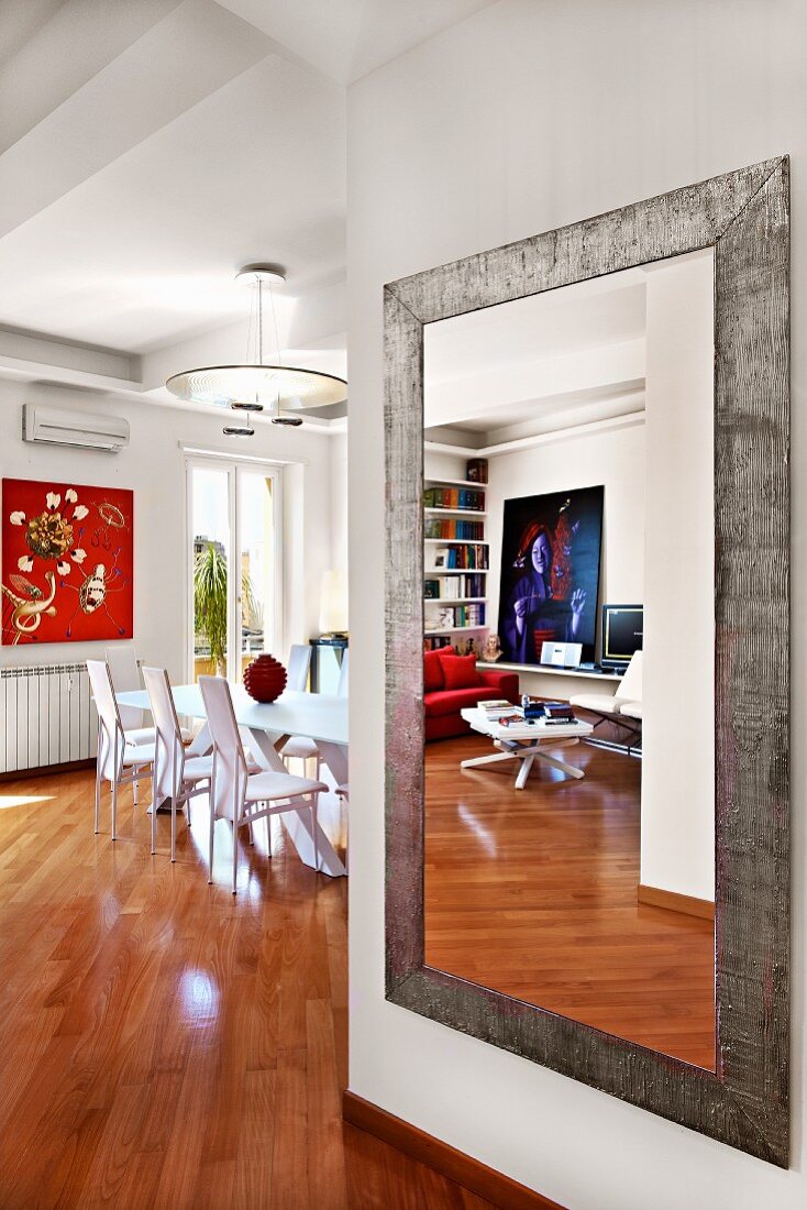 Contemporary full-length mirror on wall of living room with view into dining room