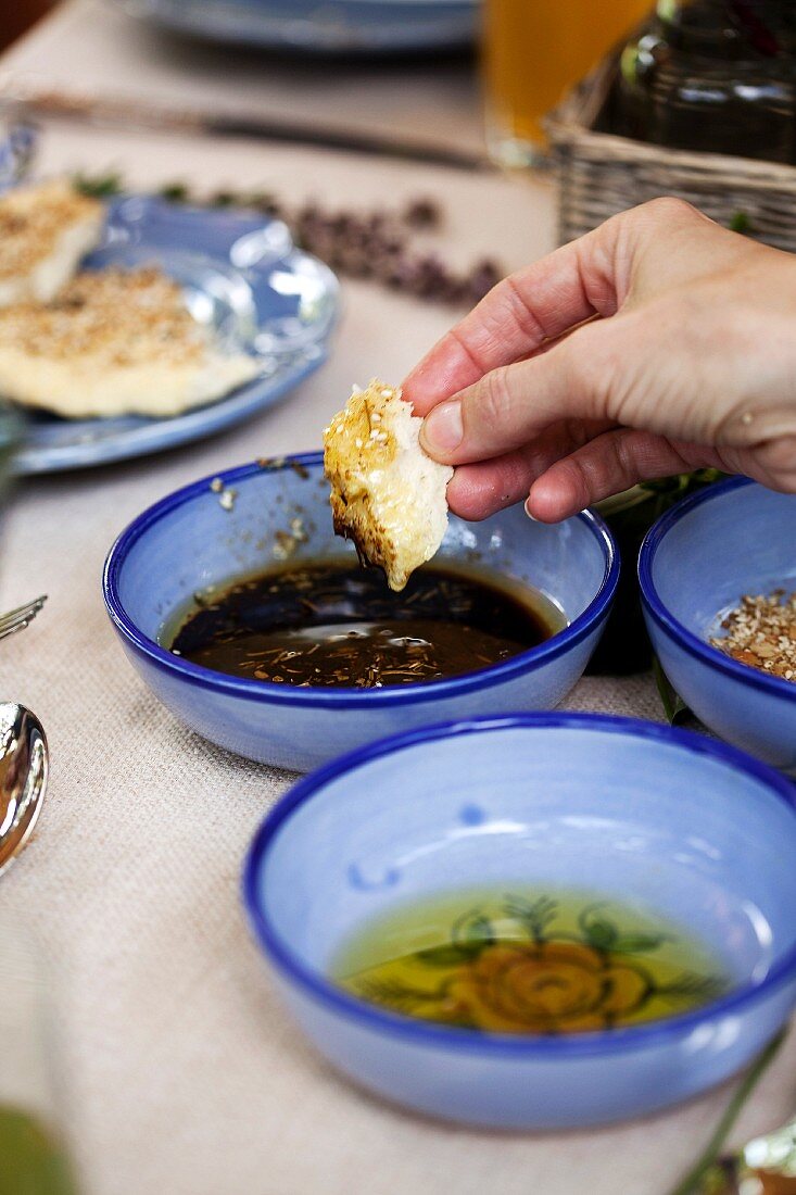 A hand dipping a chunk of bread