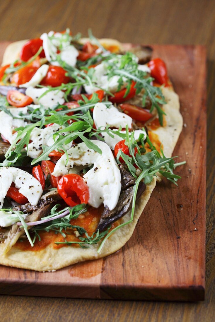 Unleavened bread topped with tomatoes, rocket and mozzarella