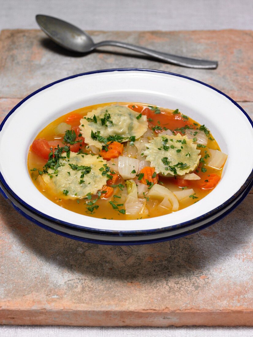 Vegetables soup with parsley ravioli