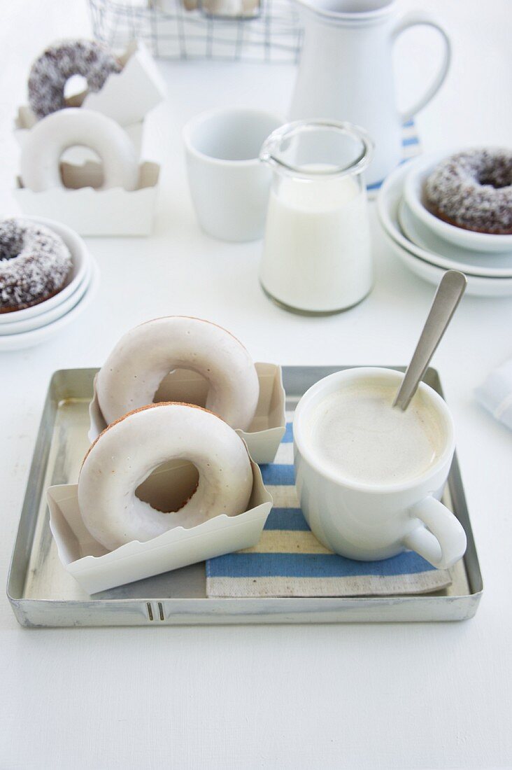 Doughnuts und eine Tasse Kaffee auf einem Tablett