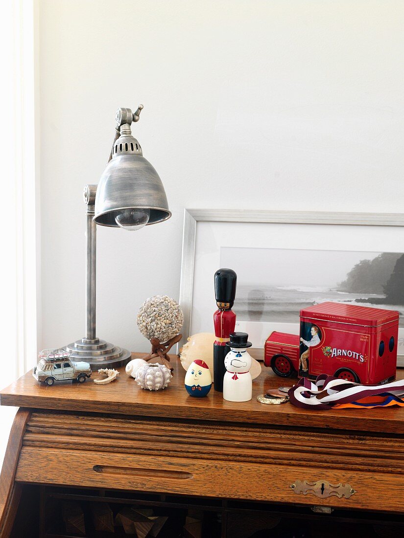 Industrial-style table lamp and toy ornaments on top surface of roll-top desk