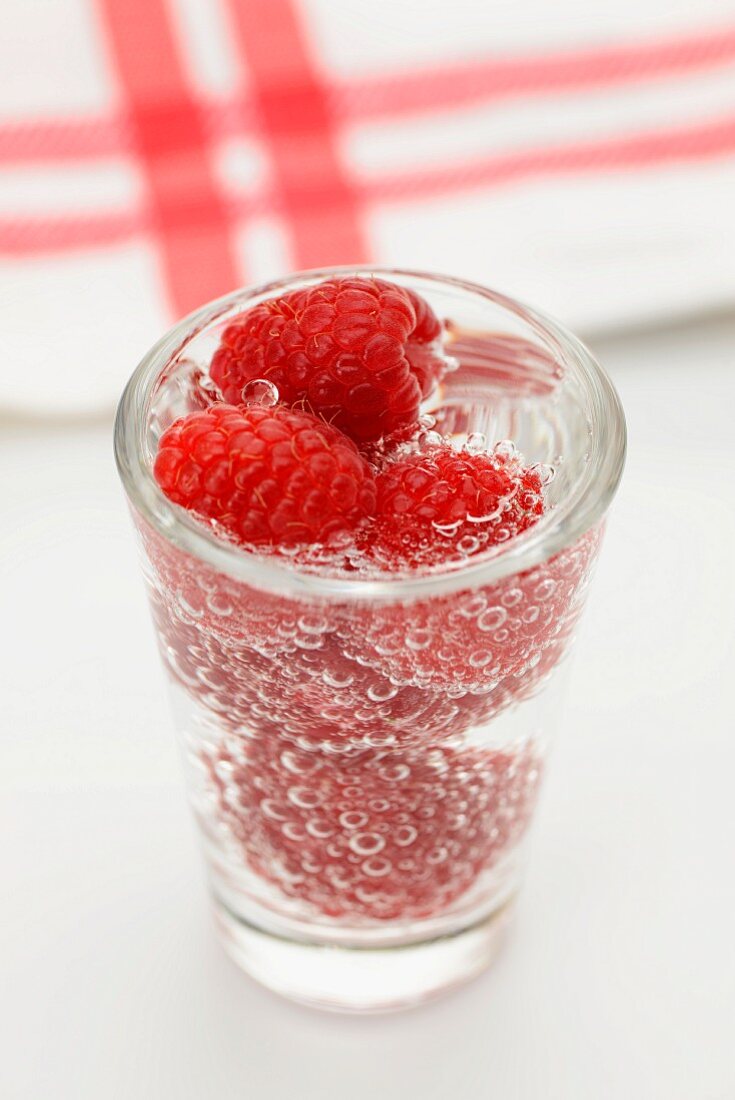 Raspberries in a glass of water