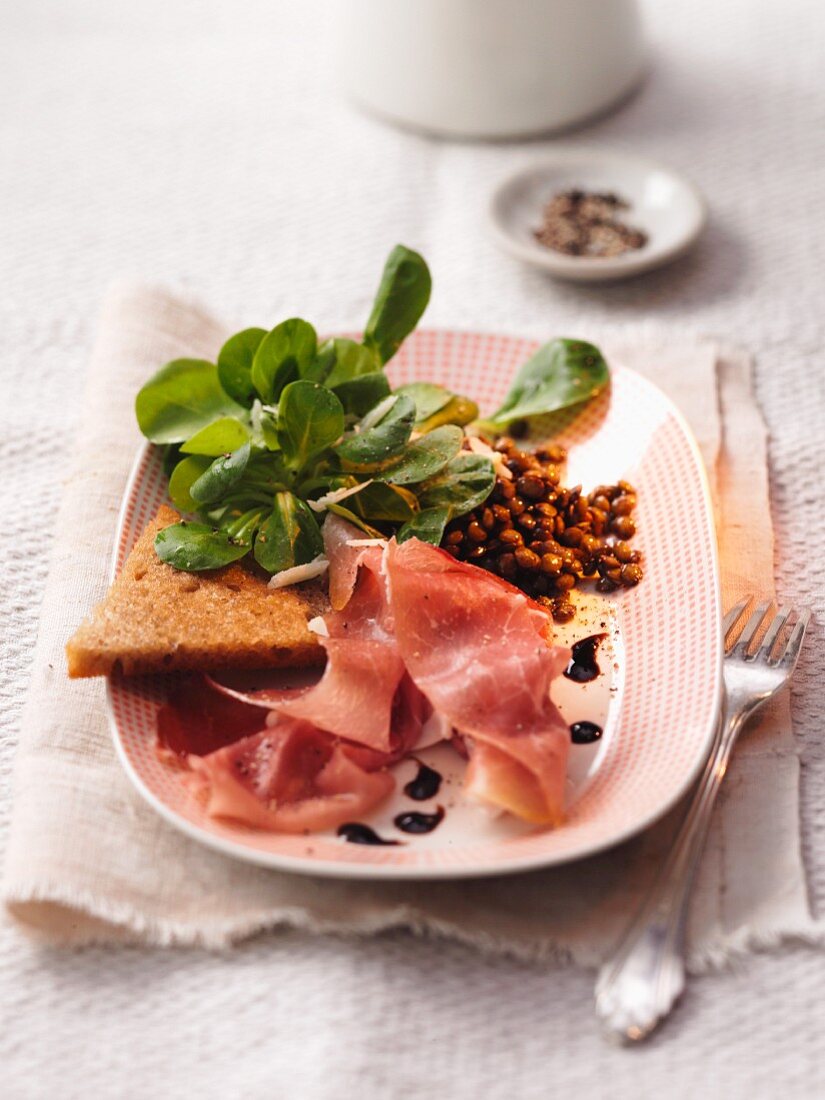 Lentil salad with raw ham and bread