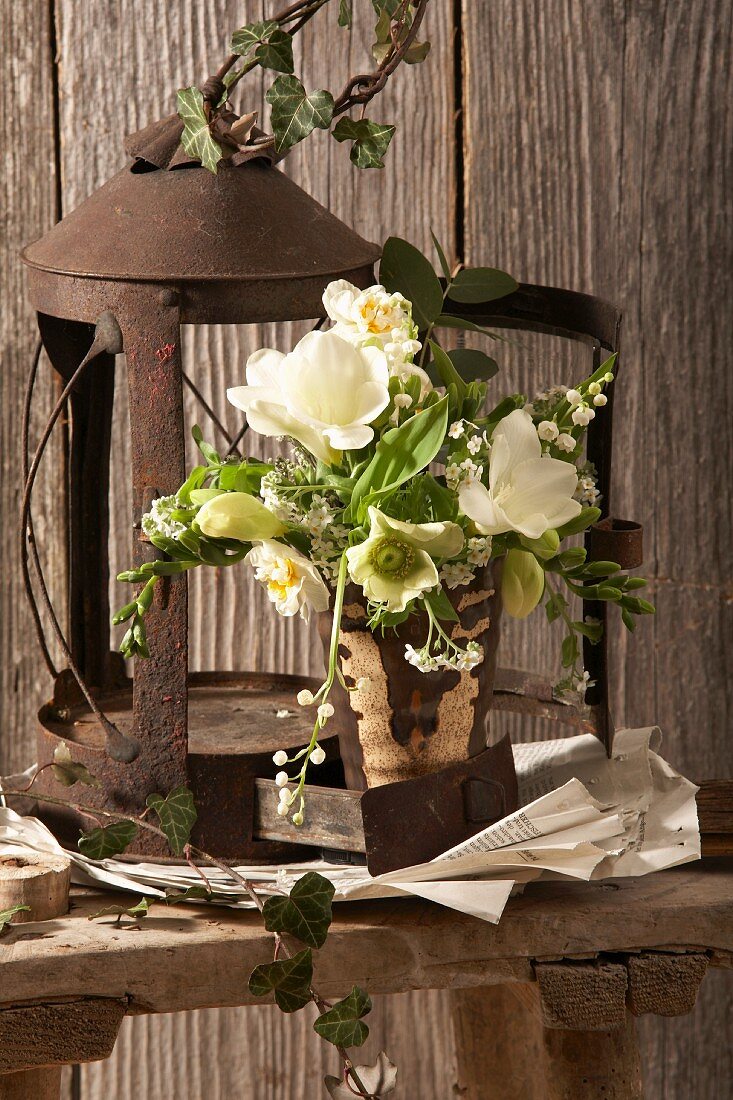 Bouquet made of white spring flowers in front of a rusty lantern