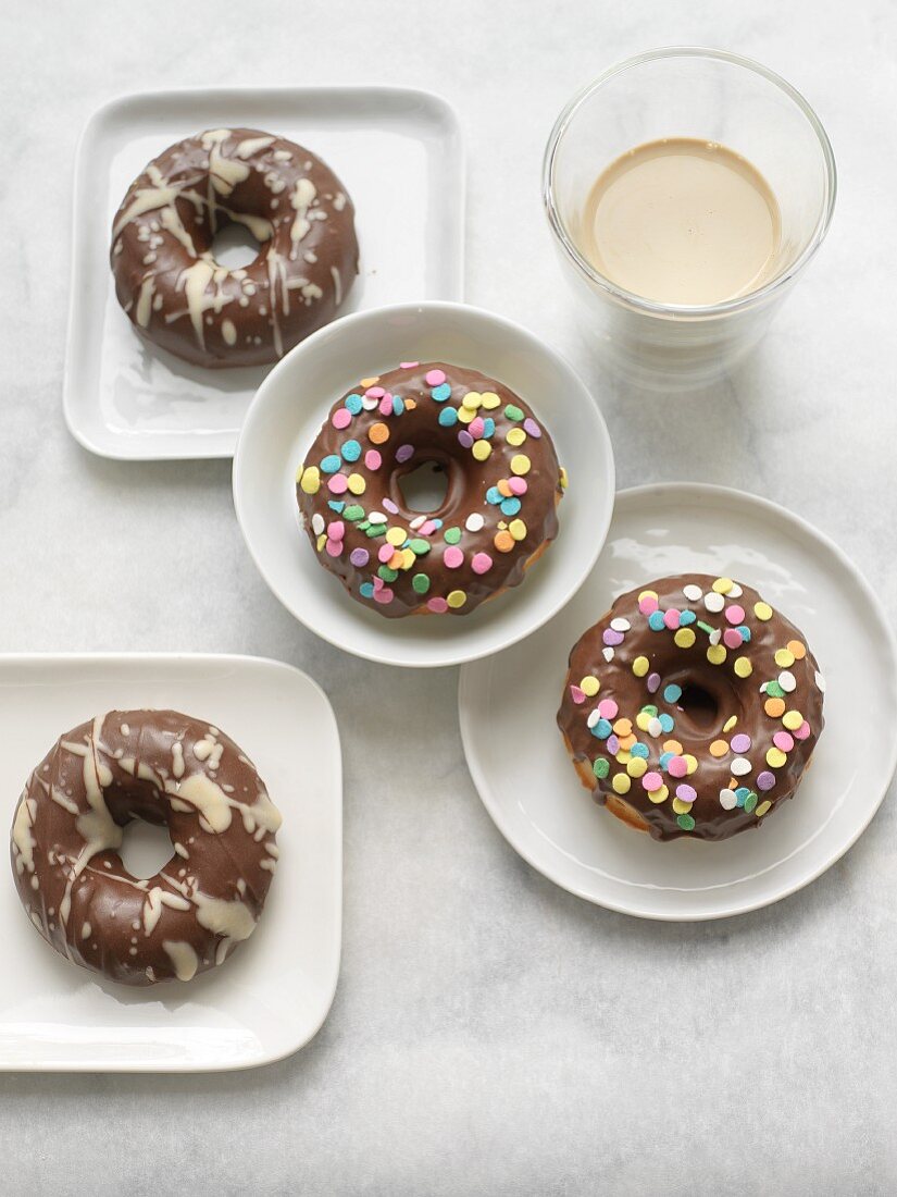 Chocolate Covered Donuts with White Chocolate Drizzles and Sprinkles