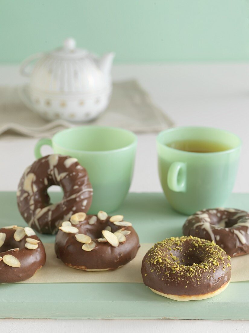 Gebackene Doughnuts mit Schokoglasur, Mandelblättchen und Pistazien