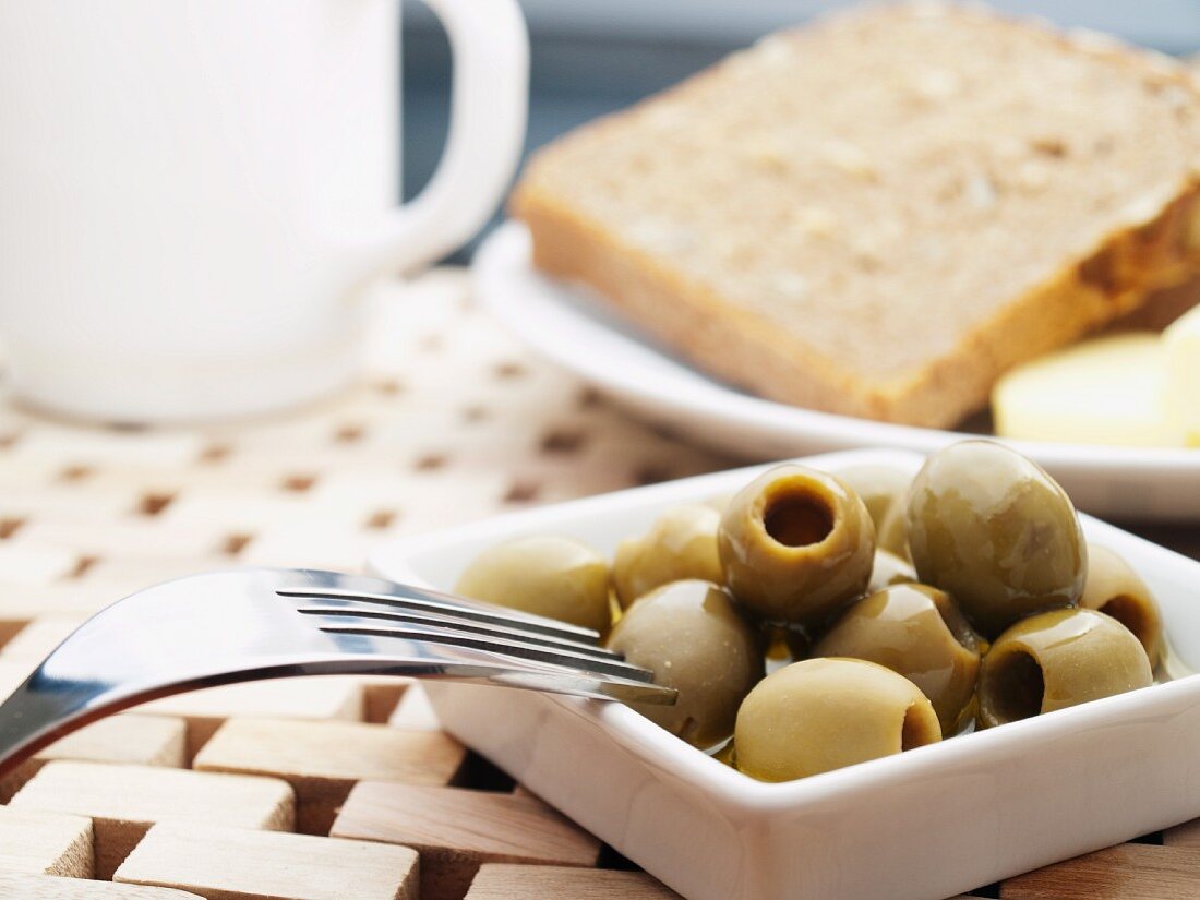 Green olives and a slice of bread