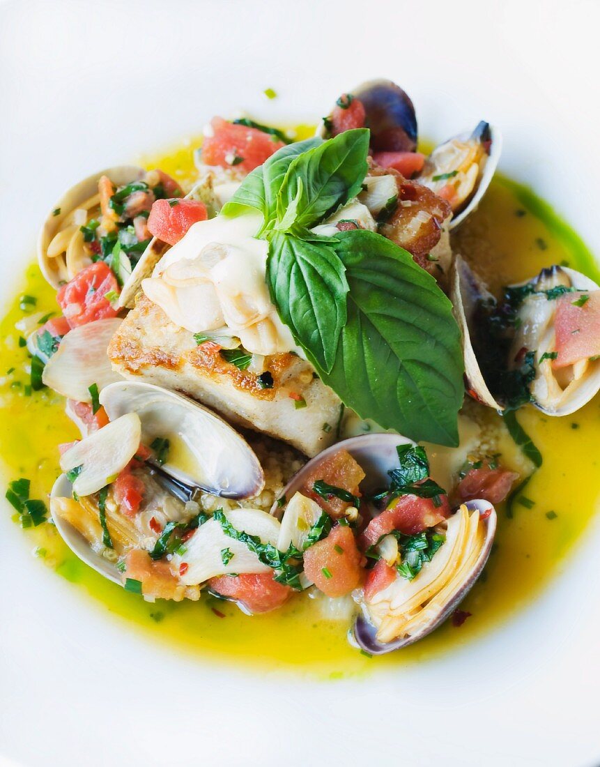 Fish and mussels with garlic sauce and basil