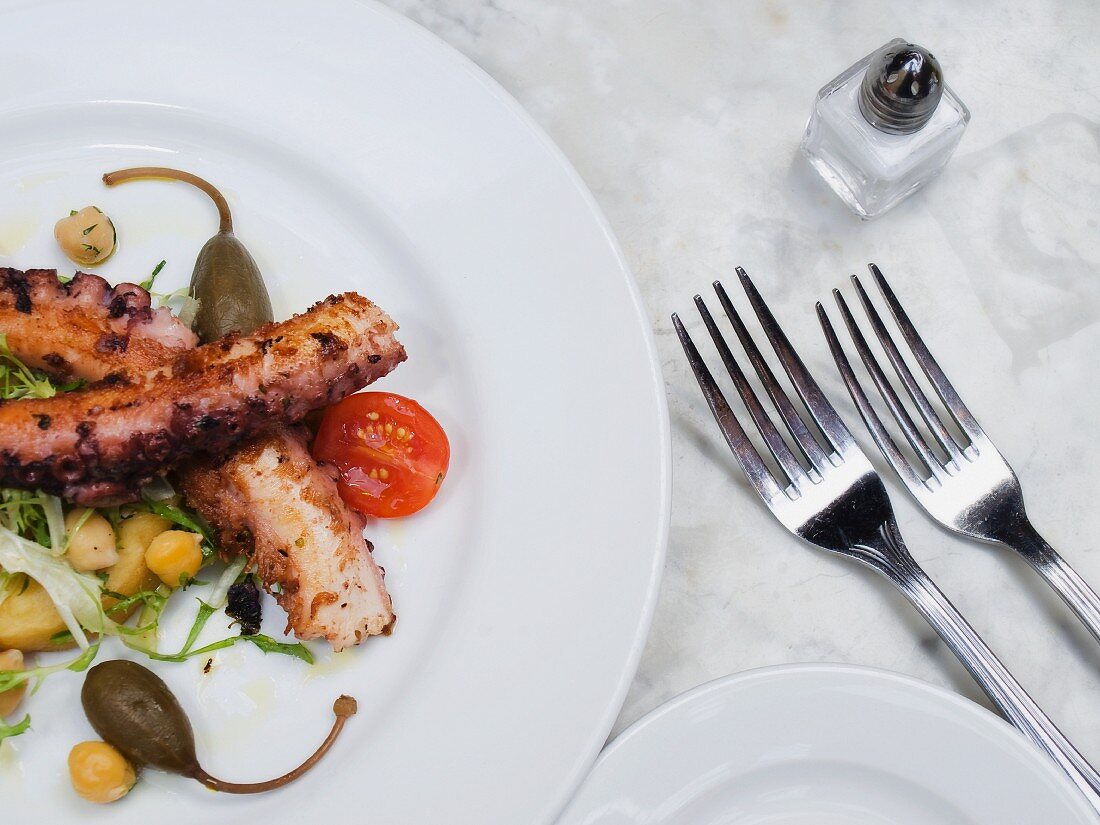 Fried octopus with cherry tomatoes, giant capers and chickpeas