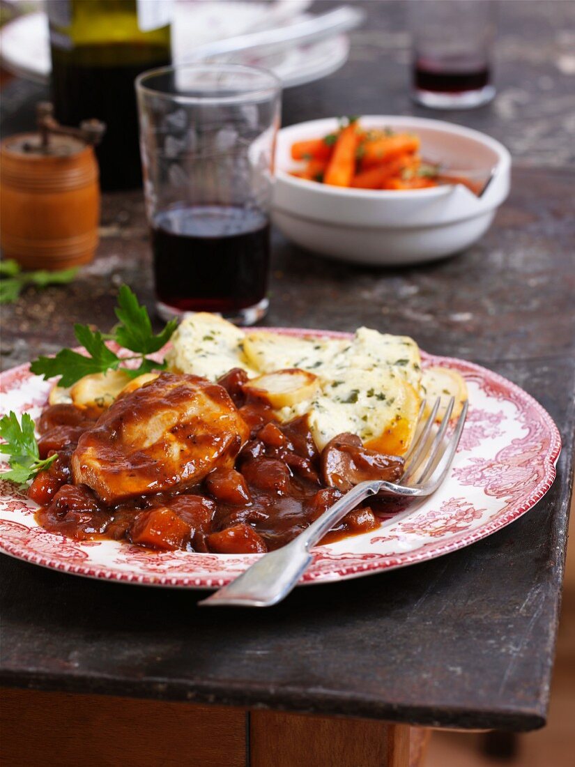 Coq au Vin mit Kartoffel-Kräuter-Gratin auf Teller