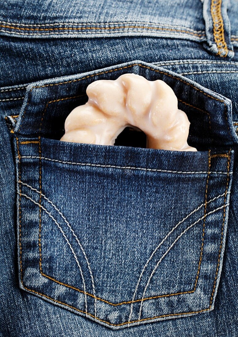 A doughnut in a jeans pocket