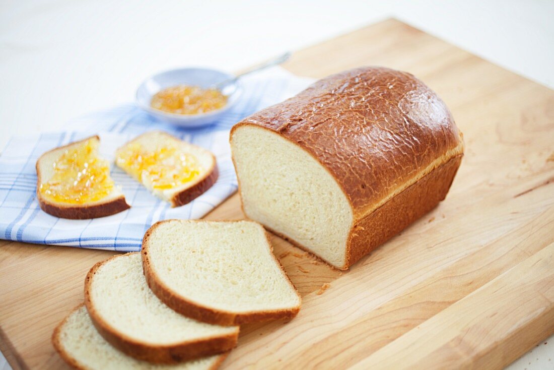 Kastenförmiges Brioche-Brot, eine Scheibe mit Marmelade