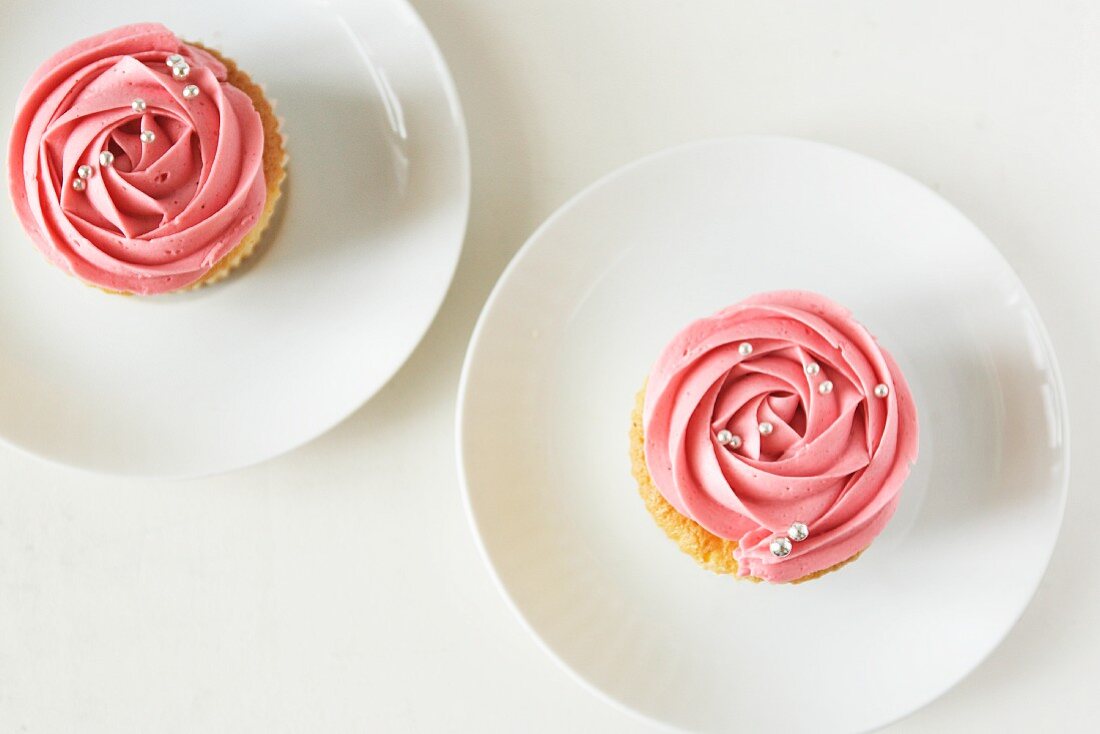 Zwei Cupcakes mit Erdbeercreme und Silberperlen
