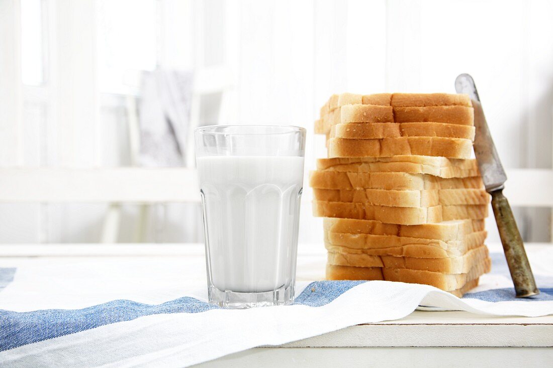 Gestapelte Toastscheiben und ein Glas Milch