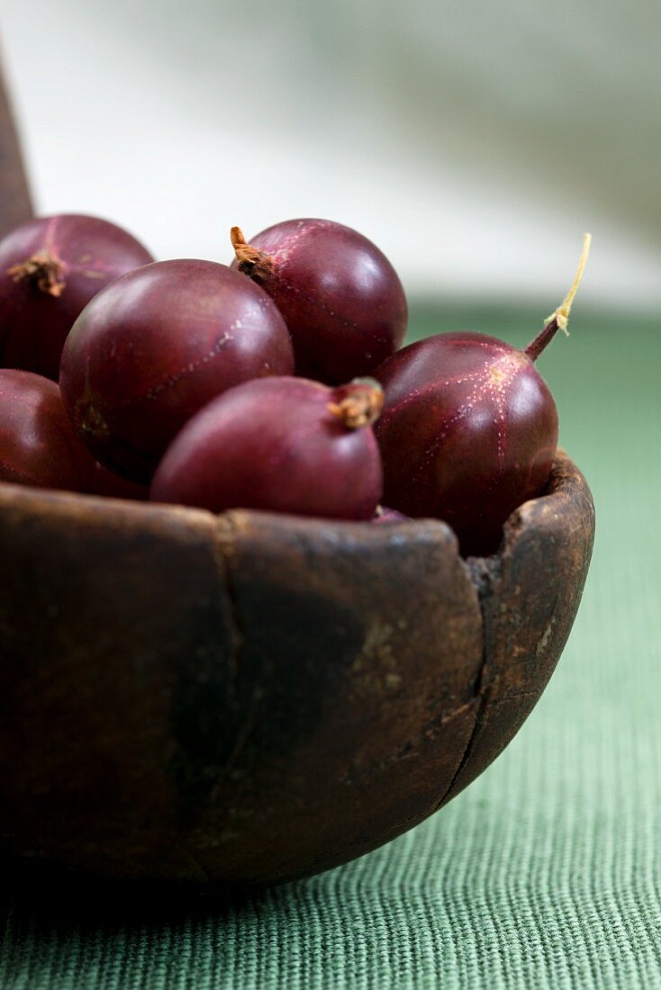 Red gooseberries in an old wooden bowl