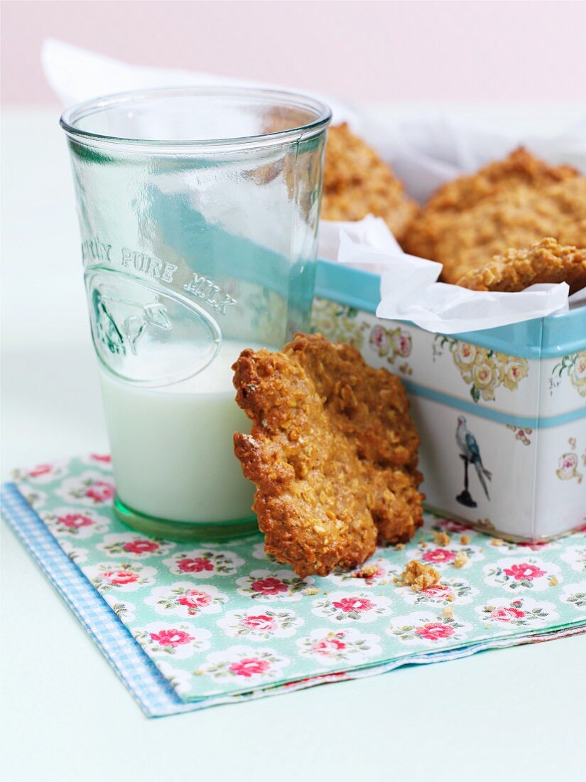 Oat and honey biscuits in a biscuit in with a glass of milk