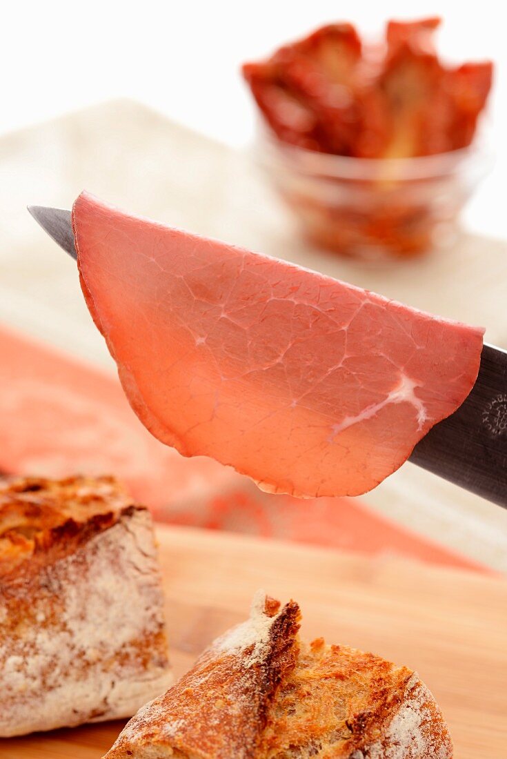 A slice of Bresaola on a knife