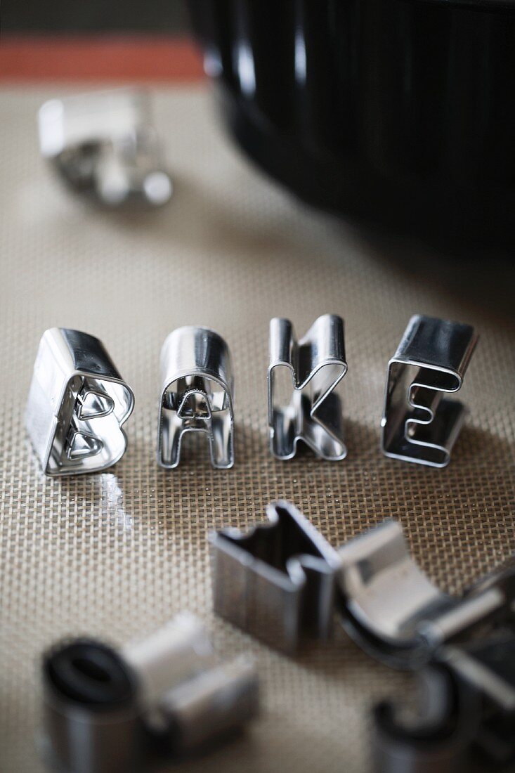 Cookie cutters spelling the word BAKE