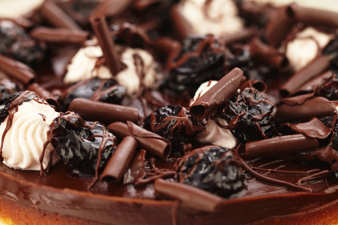 Close Up of Chocolate Curls and Dried Fruit On Top of a Cake